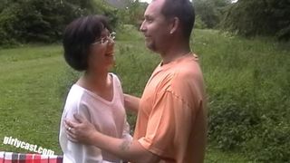 Очкастая баба делает отсос мужу и его другу на улице перед камерой